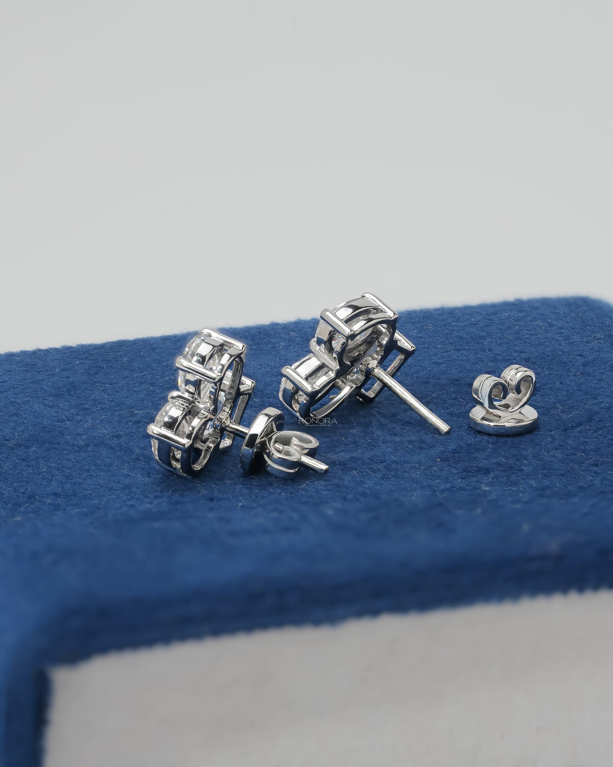 Back view of lab grown diamond cluster stud earrings showing white gold prongs, posts and butterfly backs