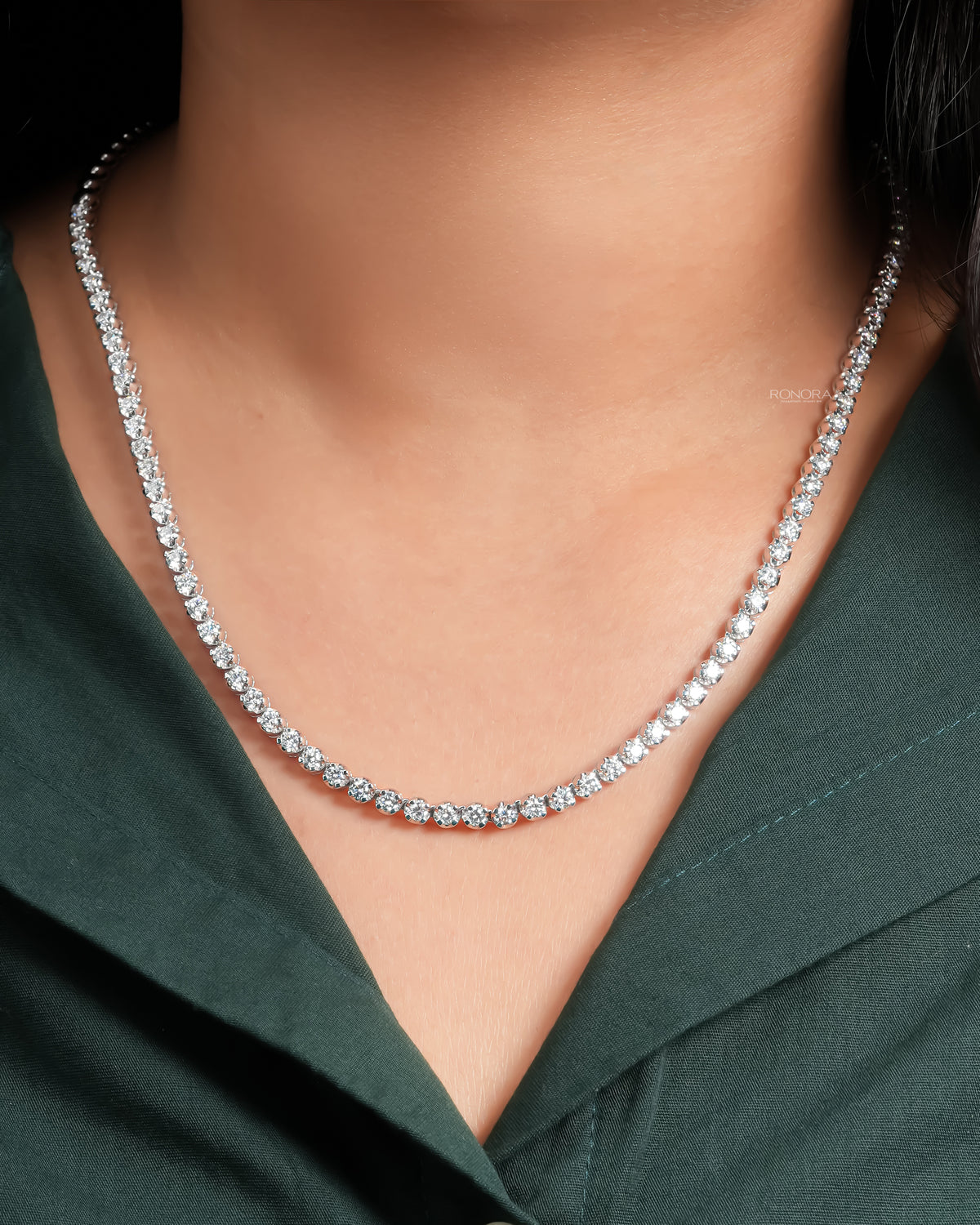 Woman wearing a round lab grown diamond tennis necklace, bright white stones in a continuous line