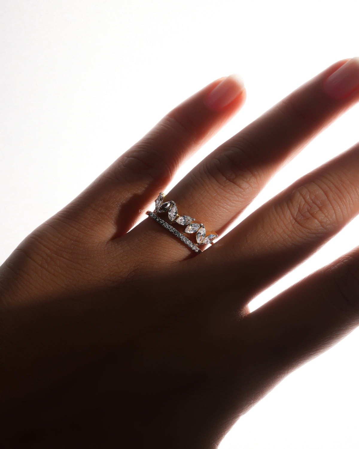 Marquise lab grown diamond leaf wrap ring with a pave side band, worn on a hand in soft backlight