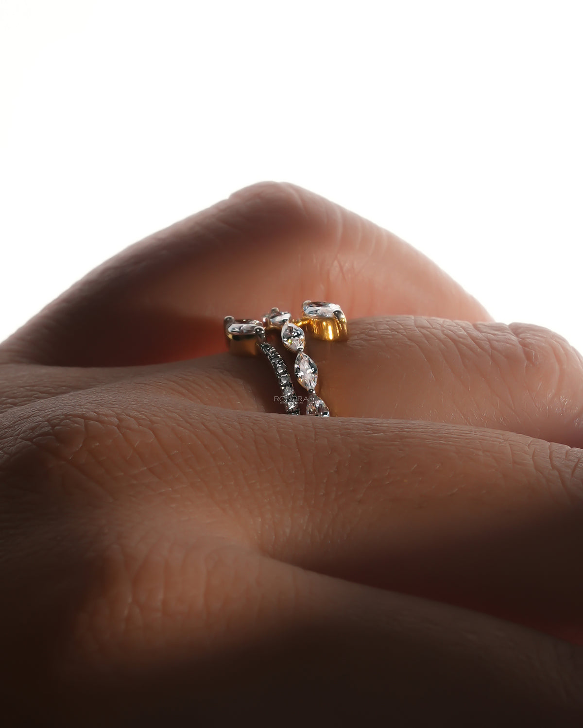 Marquise lab grown diamond vine ring worn on a finger, side view with a snake wrap band in soft backlight