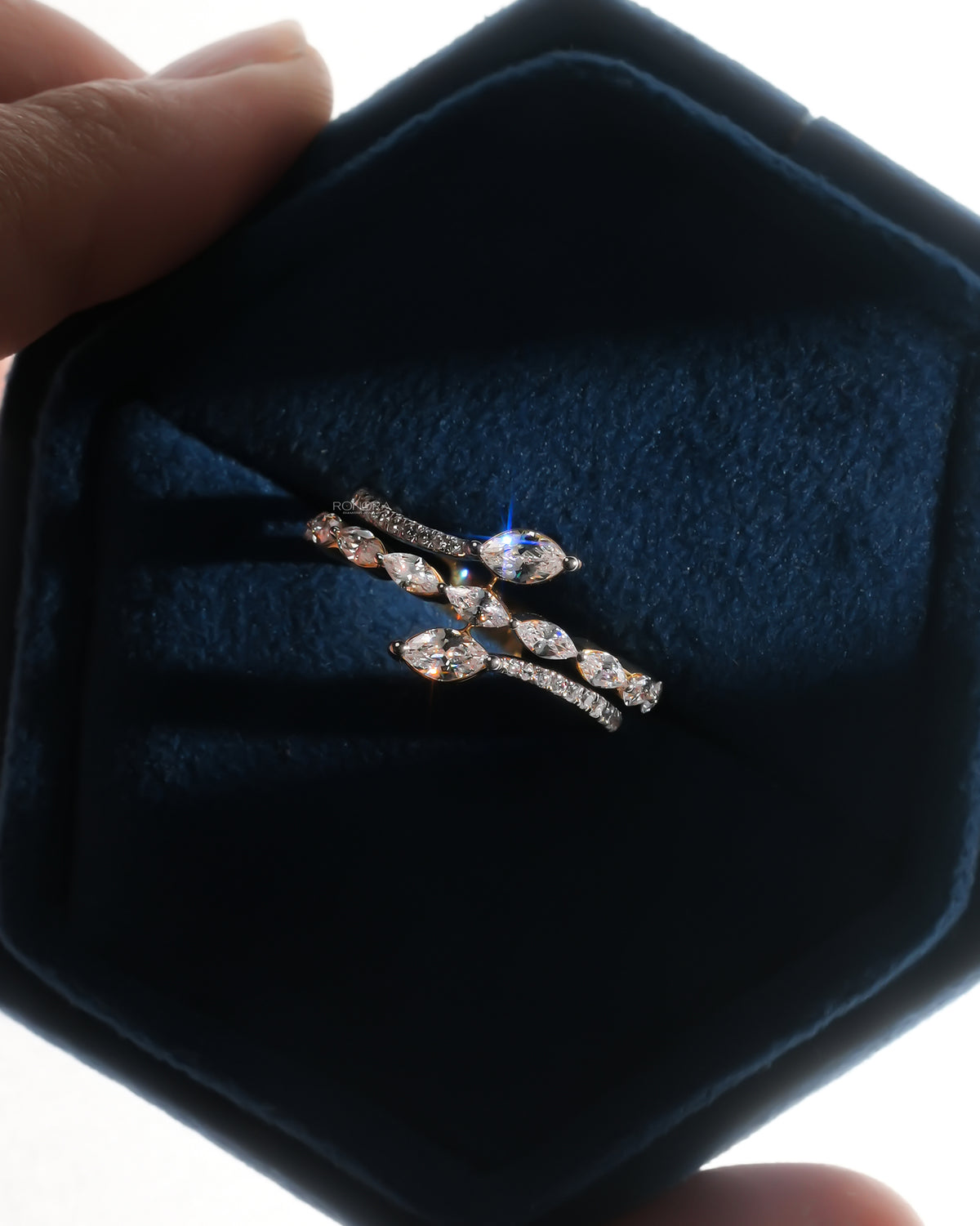 Top view of a marquise lab grown diamond vine ring with a snake wrap band in a dark blue velvet ring box