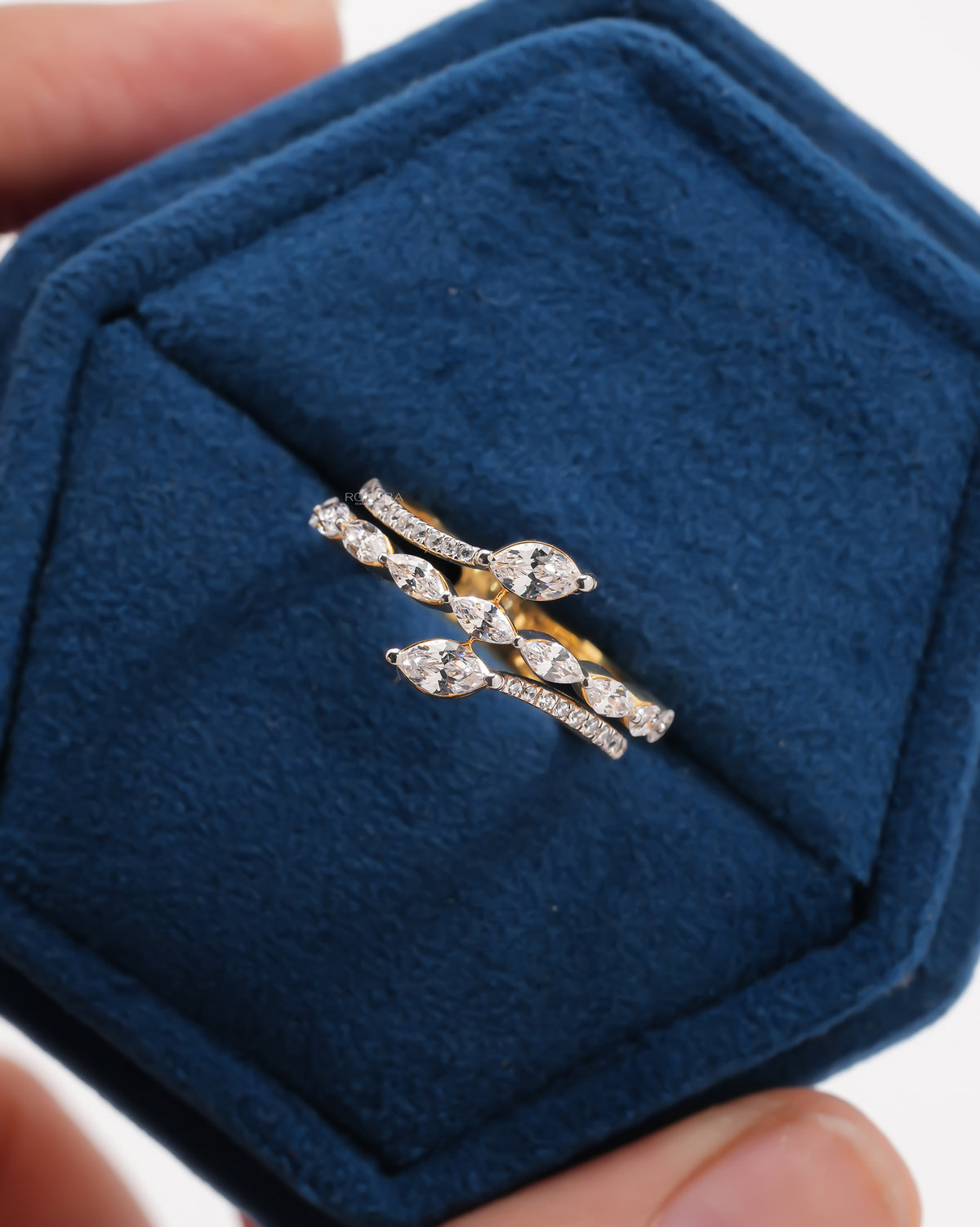 Close-up of a yellow gold marquise lab grown diamond vine ring with a pave band in a blue velvet box