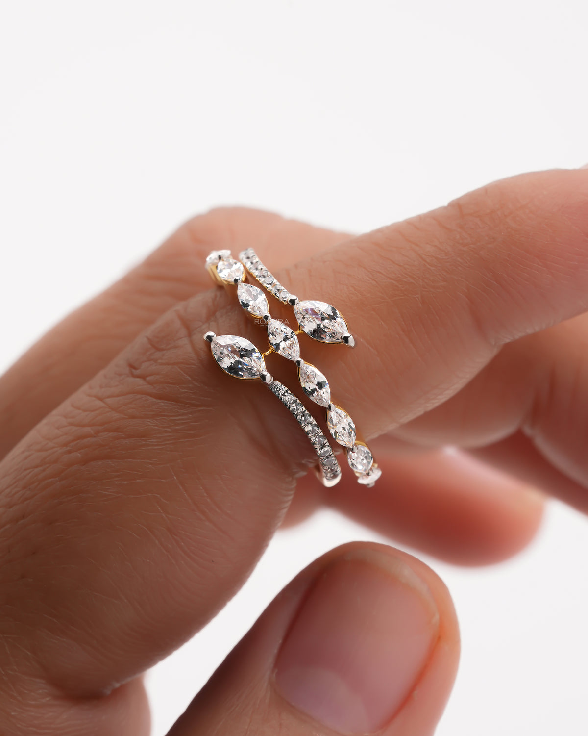 Close-up of a marquise lab grown diamond vine ring on a finger, marquise stones and pave band wrapping the finger