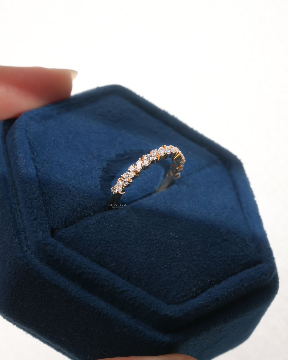 Marquise and round lab grown diamond wedding band in a blue velvet ring box, angled view of the leaf vine design