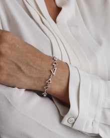 Model wearing the multi shape lab grown diamond bracelet with a cream blouse