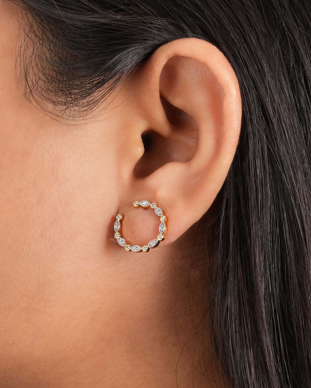 Open circle lab grown diamond earrings, one showing the post and butterfly back, in a blue velvet box