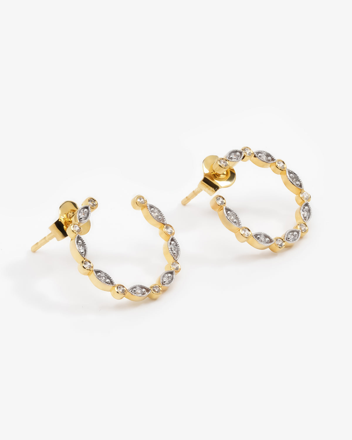 Open circle lab grown diamond earring in yellow gold and white gold on a woman's ear, close-up