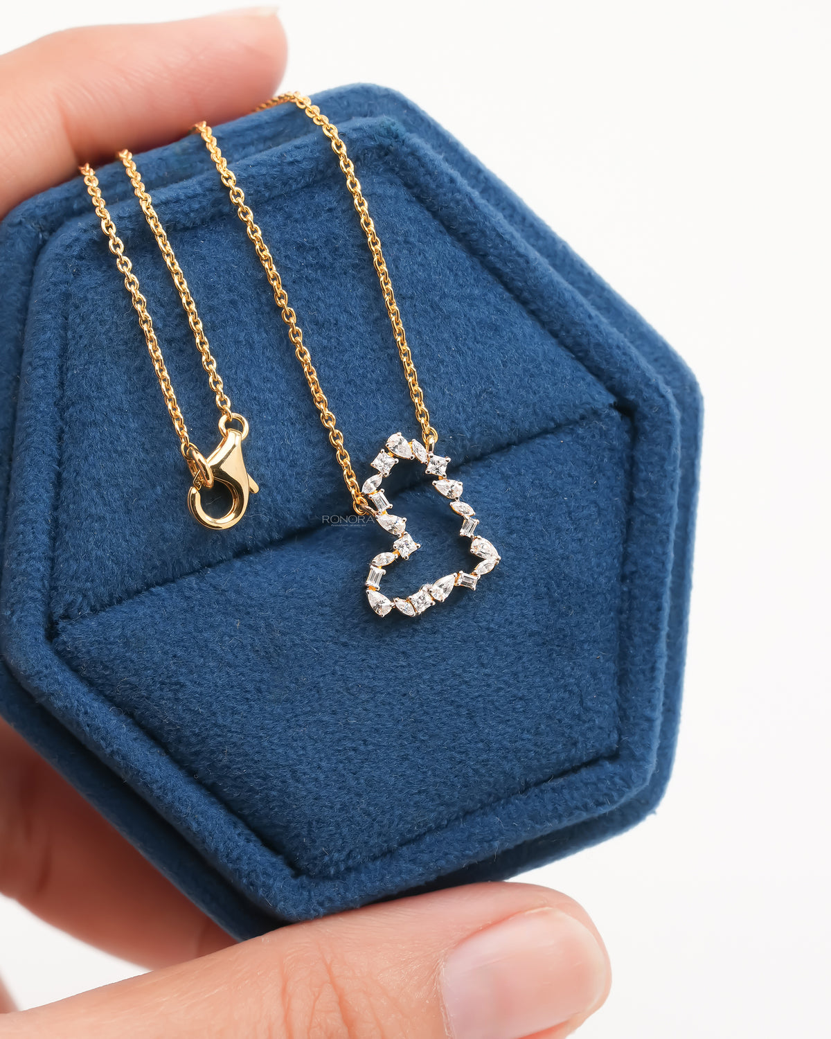 Open heart lab grown diamond pendant necklace with mixed shape stones on a gold chain in a blue velvet box