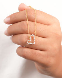 Open heart lab grown diamond pendant necklace with mixed shape stones hanging over a hand