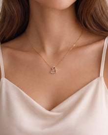 Model wearing an open heart lab grown diamond pendant necklace with mixed shape stones on a gold chain