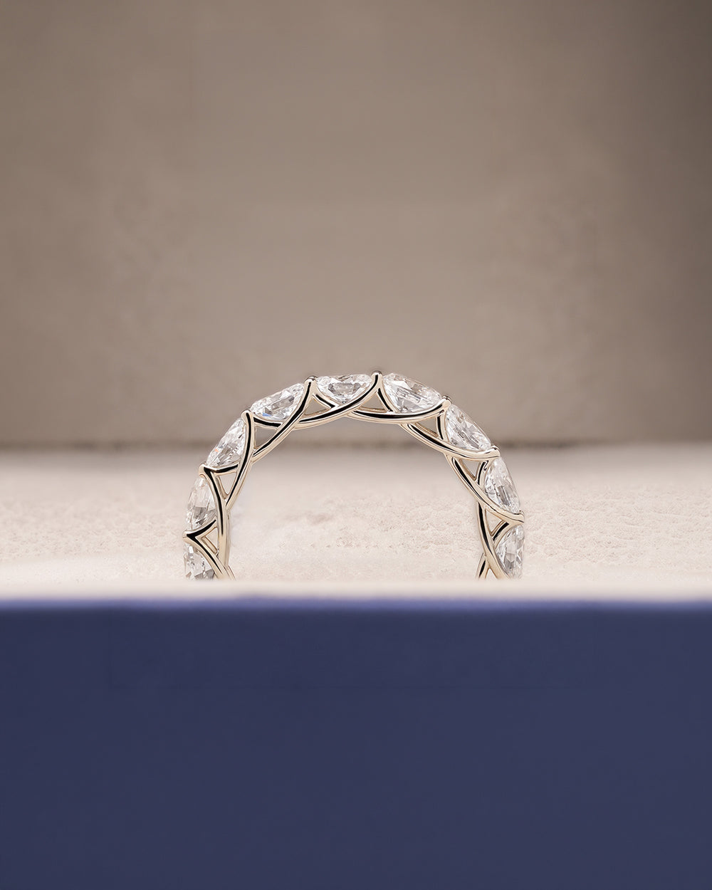 Angled view of oval lab grown diamond eternity band with eternity setting