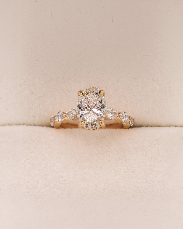Oval side stone lab grown diamond engagement ring in yellow gold inside Ronora box
