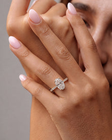 Model wearing an oval pave lab grown diamond engagement ring with a slim pave band, hands raised to her face