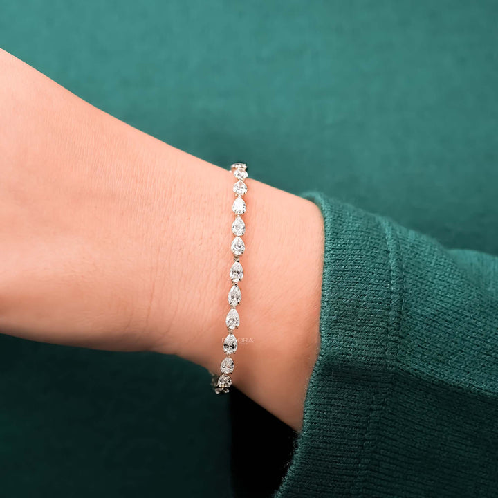 Pear lab grown diamond tennis bracelet worn with green sleeve