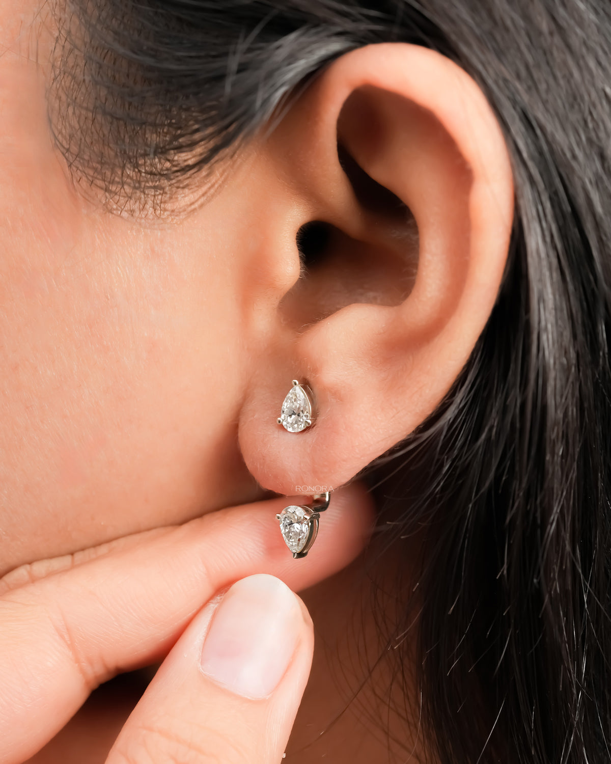 Pear lab grown diamond ear jacket earring worn on the ear with the second pear diamond sitting below the lobe