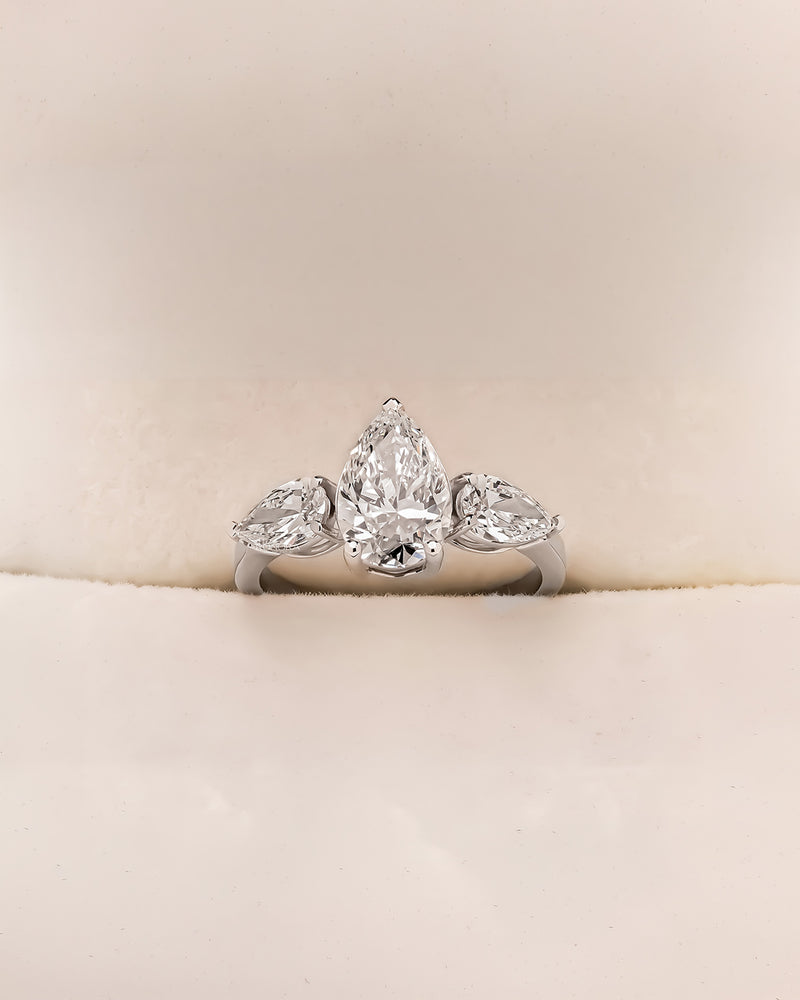 Pear three stone lab grown diamond engagement ring in white metal inside Ronora box