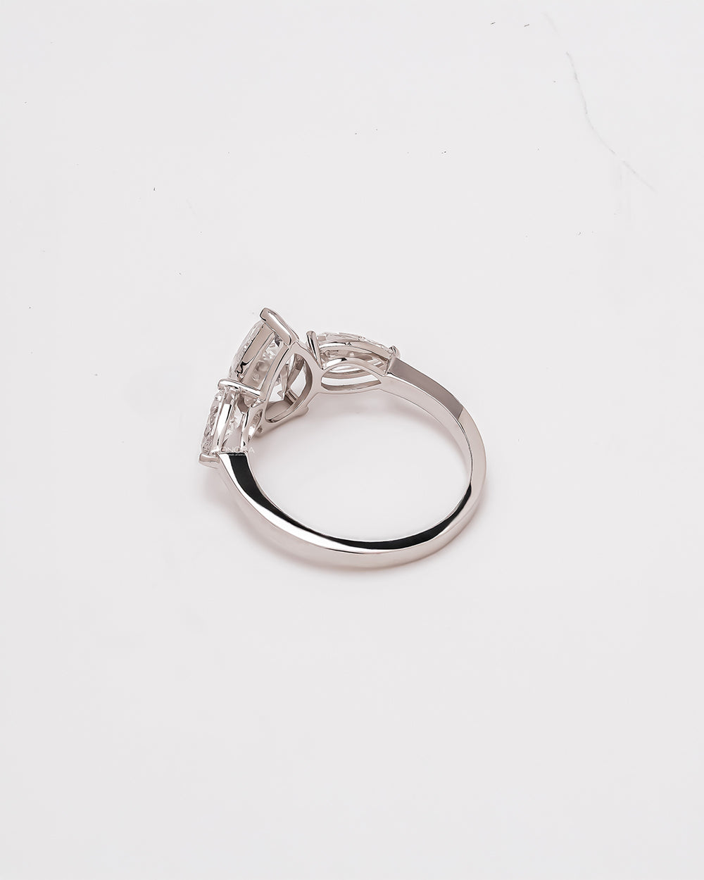 Side profile of pear three stone lab grown diamond engagement ring showing band