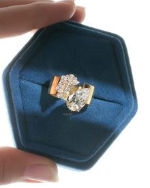 Pear toi et moi lab grown diamond ring in yellow gold in a blue velvet hexagon ring box, top view