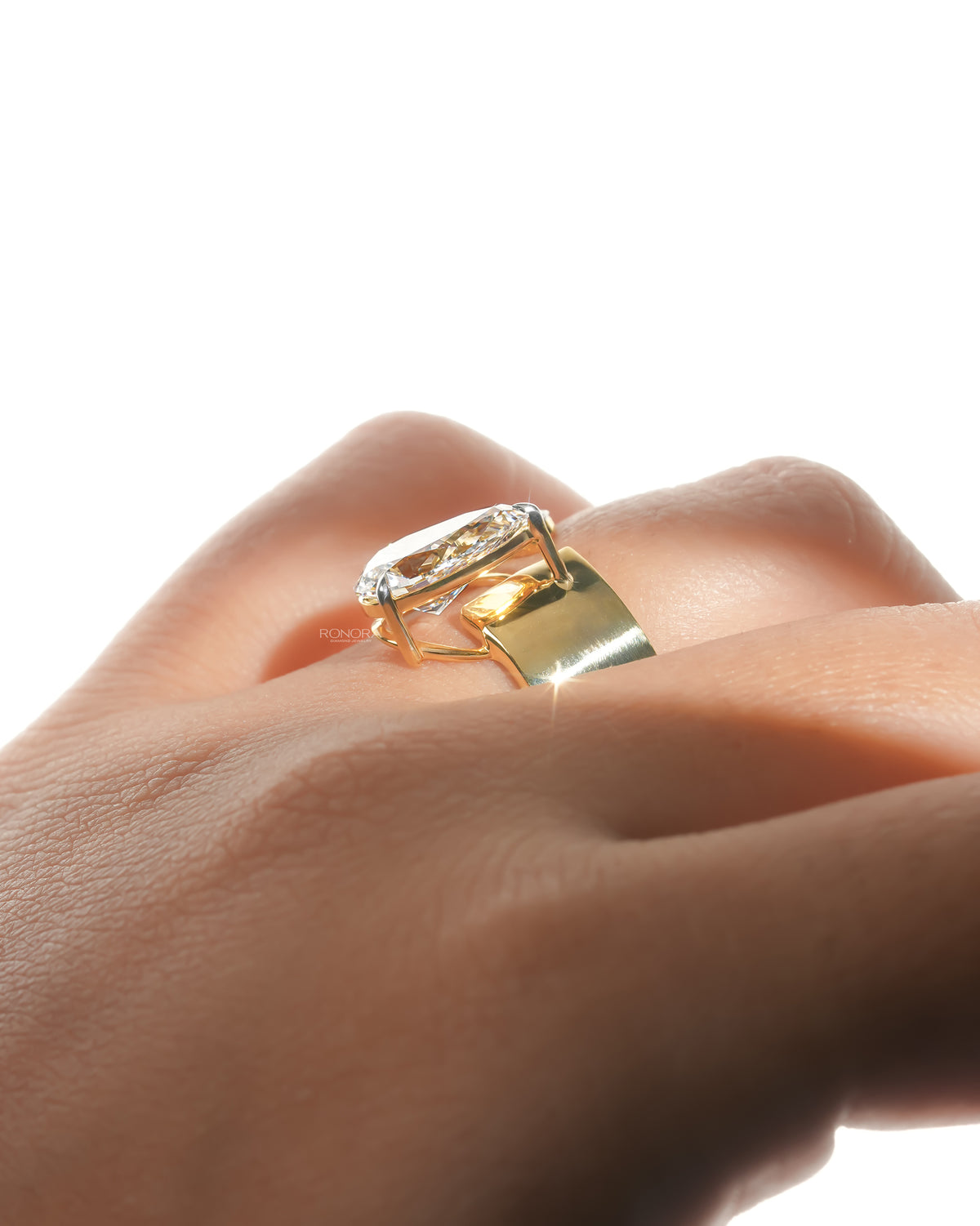 Side angle of a pear toi et moi lab grown diamond ring in yellow gold worn on a finger