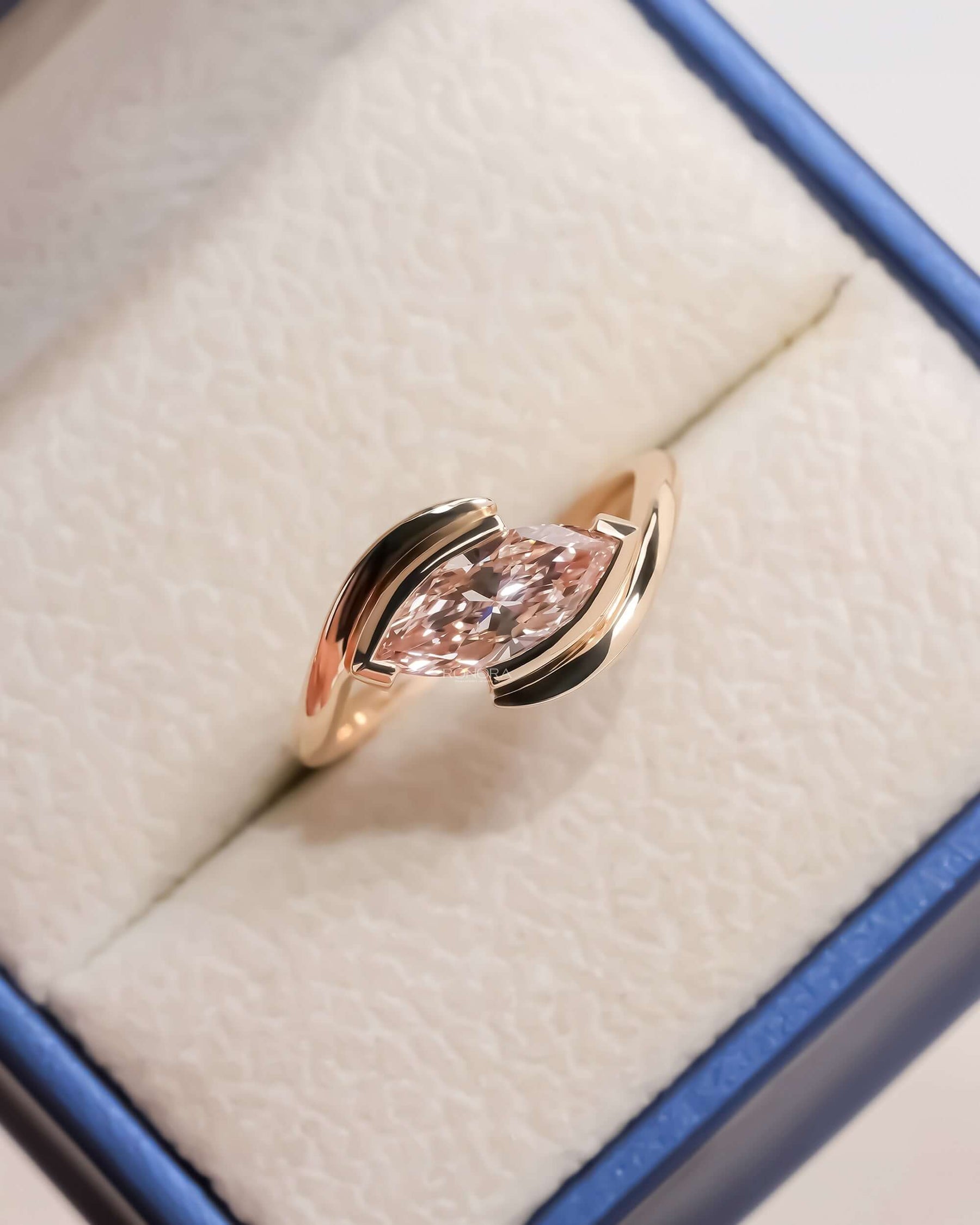 pink marquise lab grown diamond twist ring worn on hand in rose gold