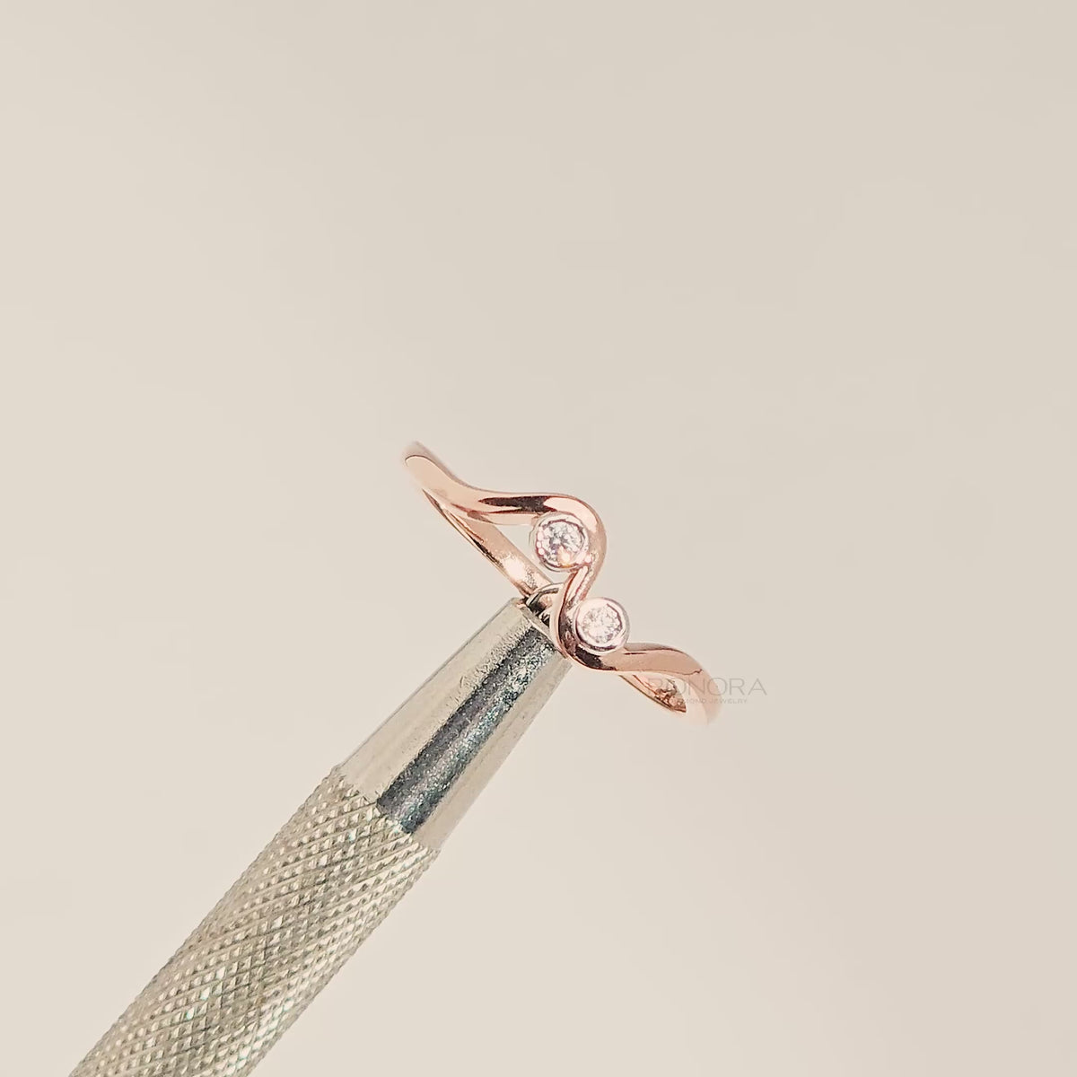 Close-up video of two-stone lab grown diamond wave ring with round bezel settings