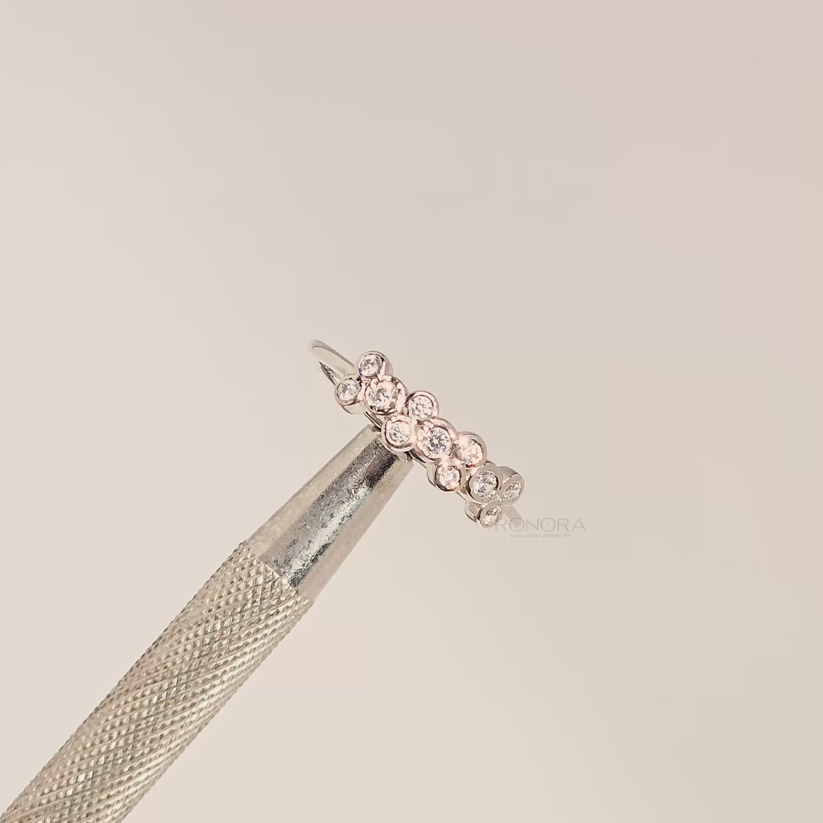 Close-up video of round lab grown diamond five-stone band in white metal