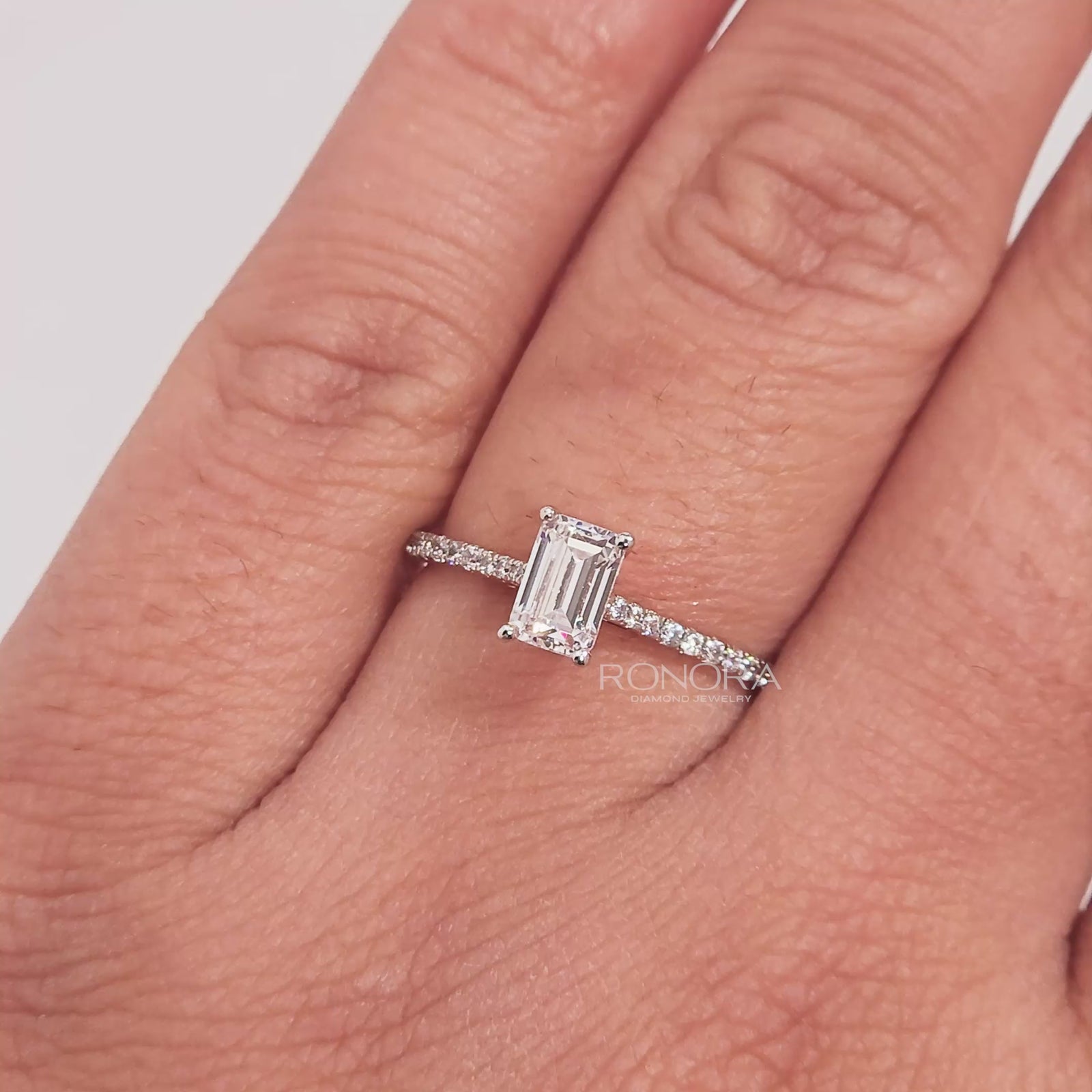 Close-up video of emerald cut moissanite pave ring in rose gold