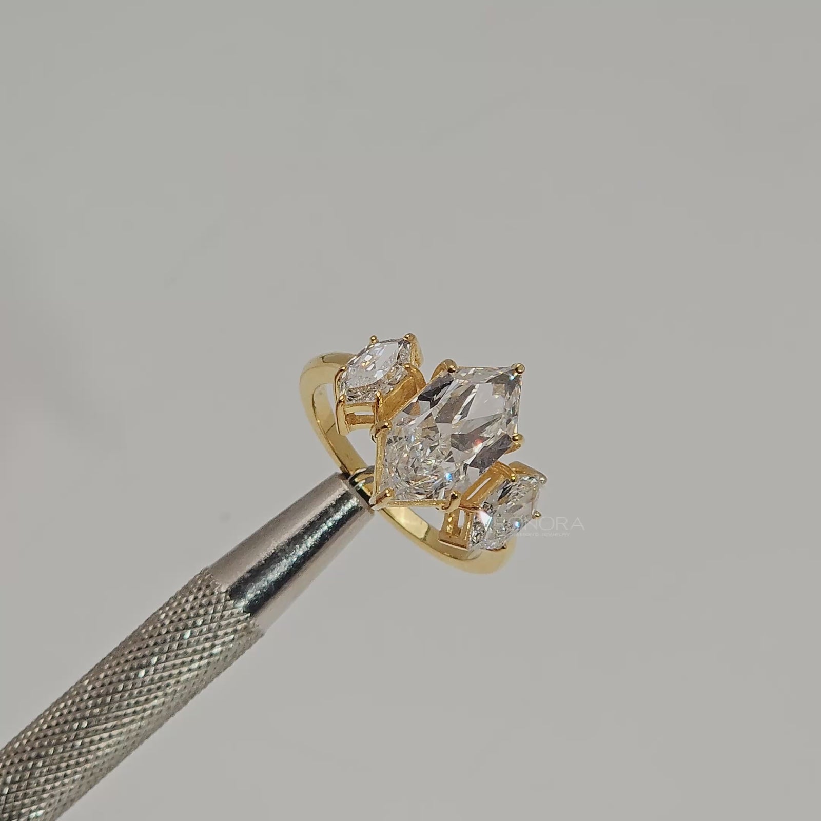 Close-up video of marquise lab grown diamond three-stone ring in yellow gold