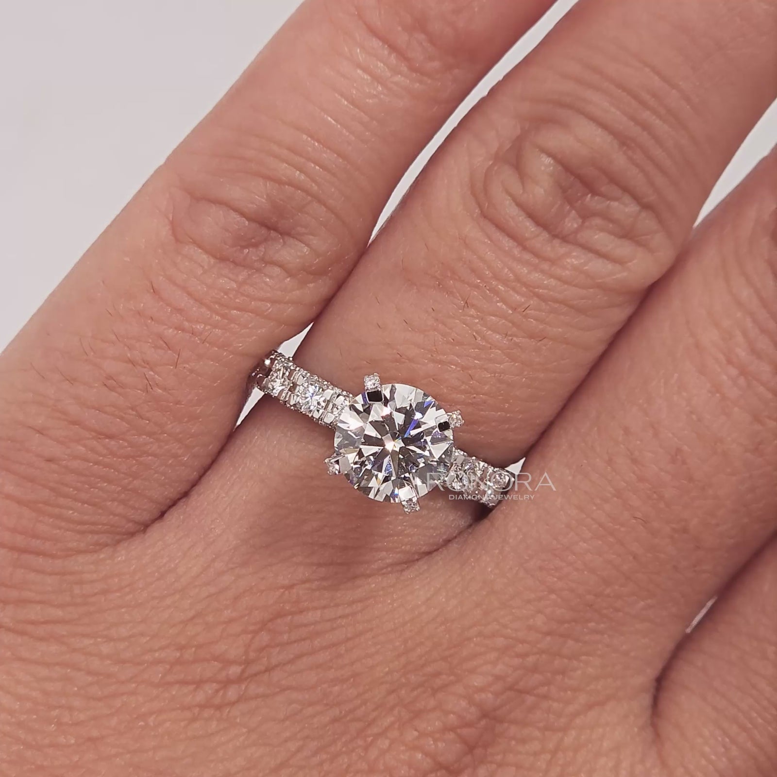 Close-up video of round lab grown diamond side-stone ring in white gold