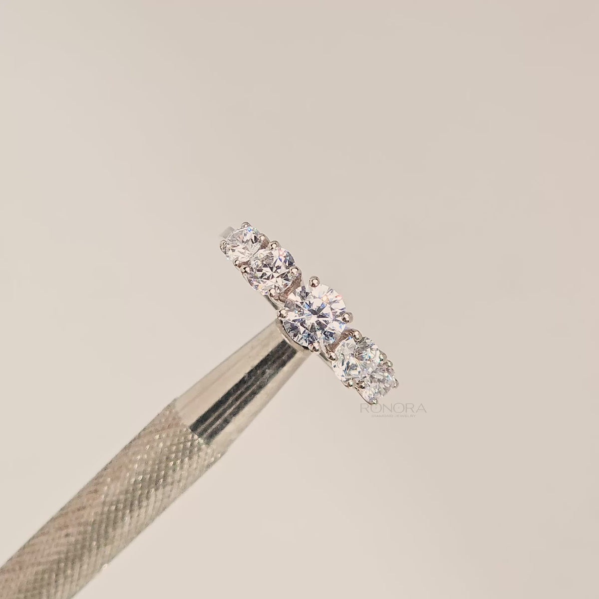 Close-up video of round lab grown diamond five-stone ring with graduated stones