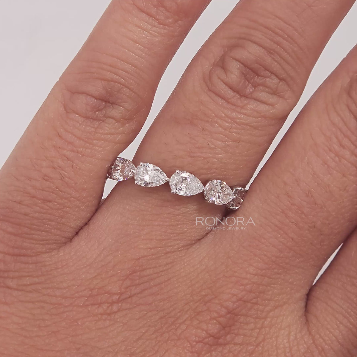 Close-up video of pear lab grown diamond eternity band in white gold