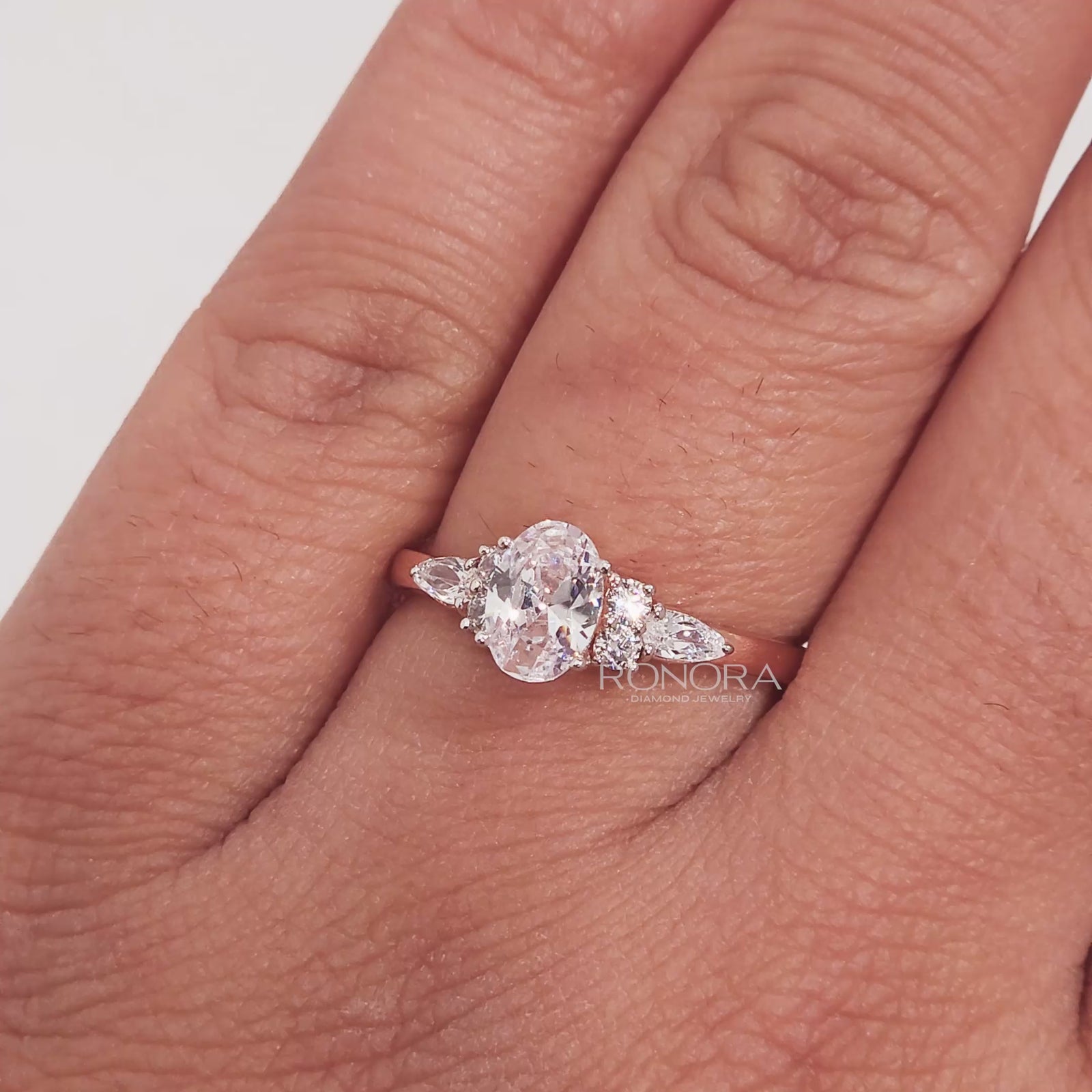 Close-up video of oval pear moissanite cluster ring in rose gold