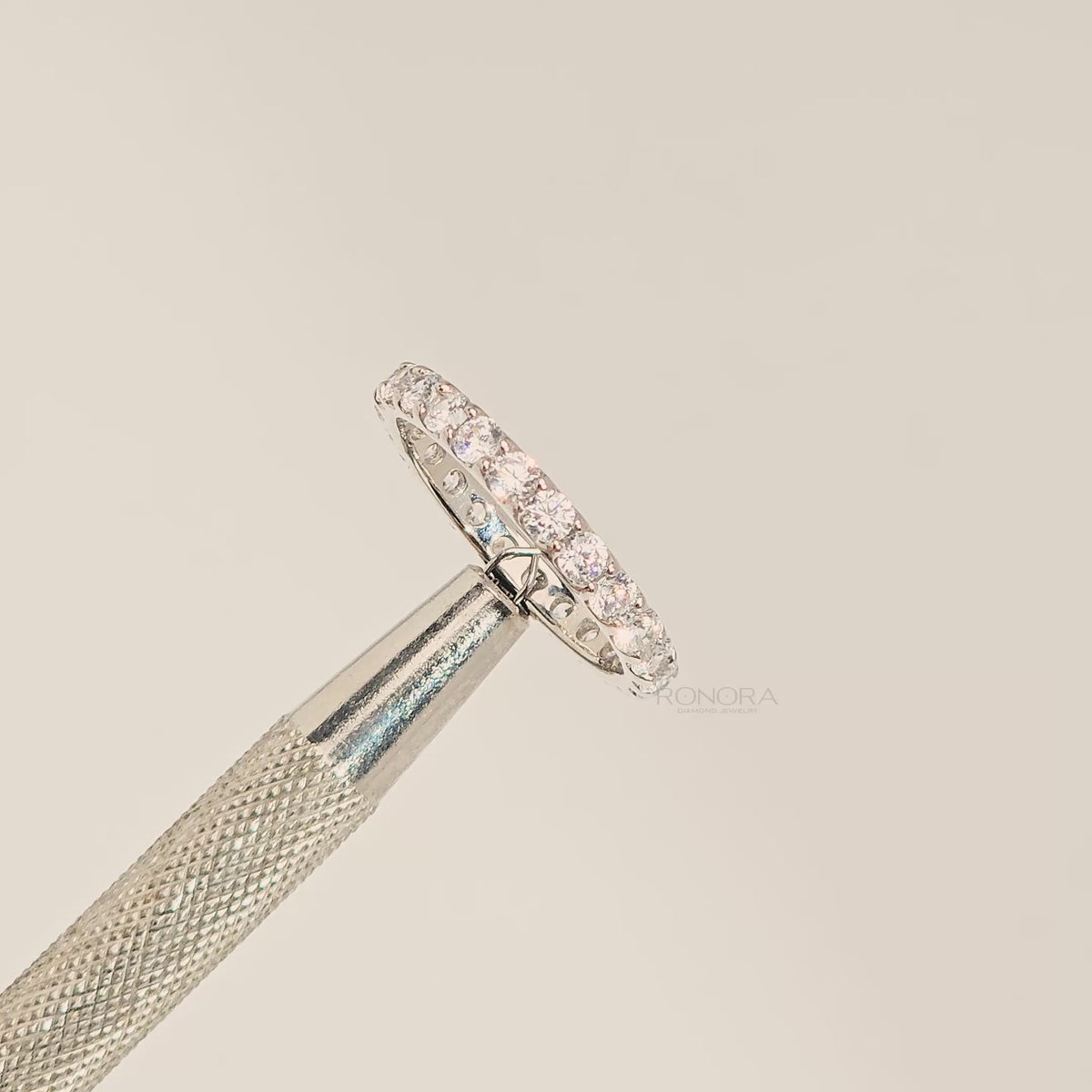 Close-up video of round lab grown diamond eternity band in white metal