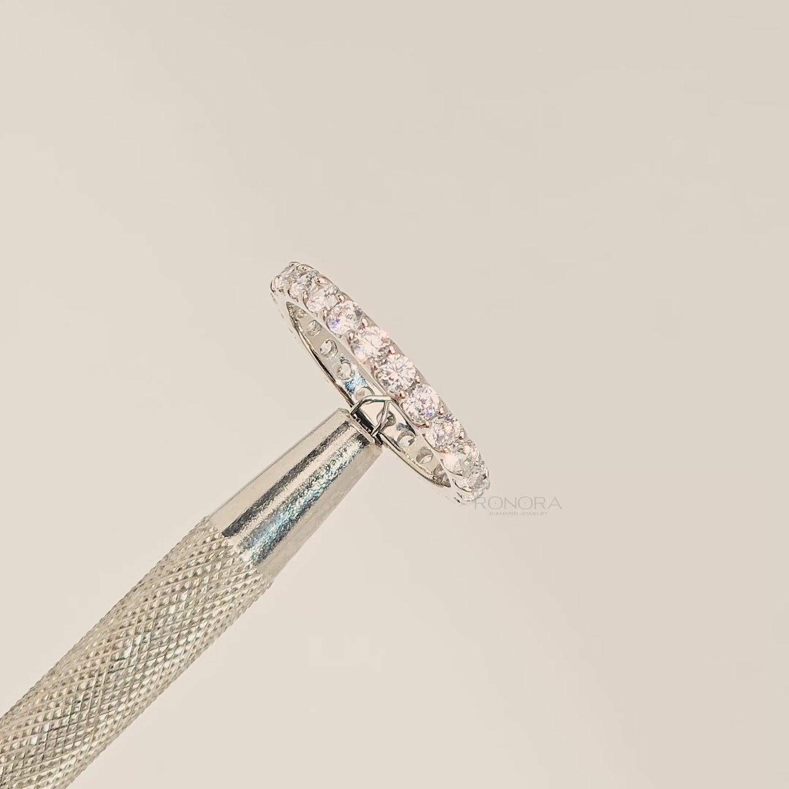 Close-up video of round lab grown diamond eternity band in white metal