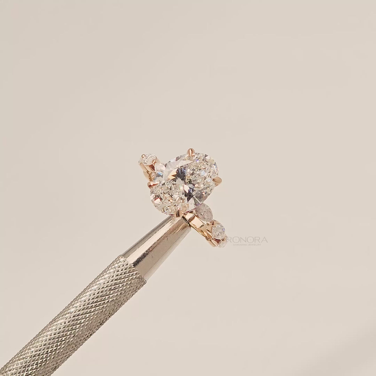 Close-up video of oval lab grown diamond side-stone ring in yellow gold