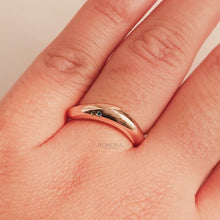 Close-up video of blue accent lab grown diamond curved ring in rose gold
