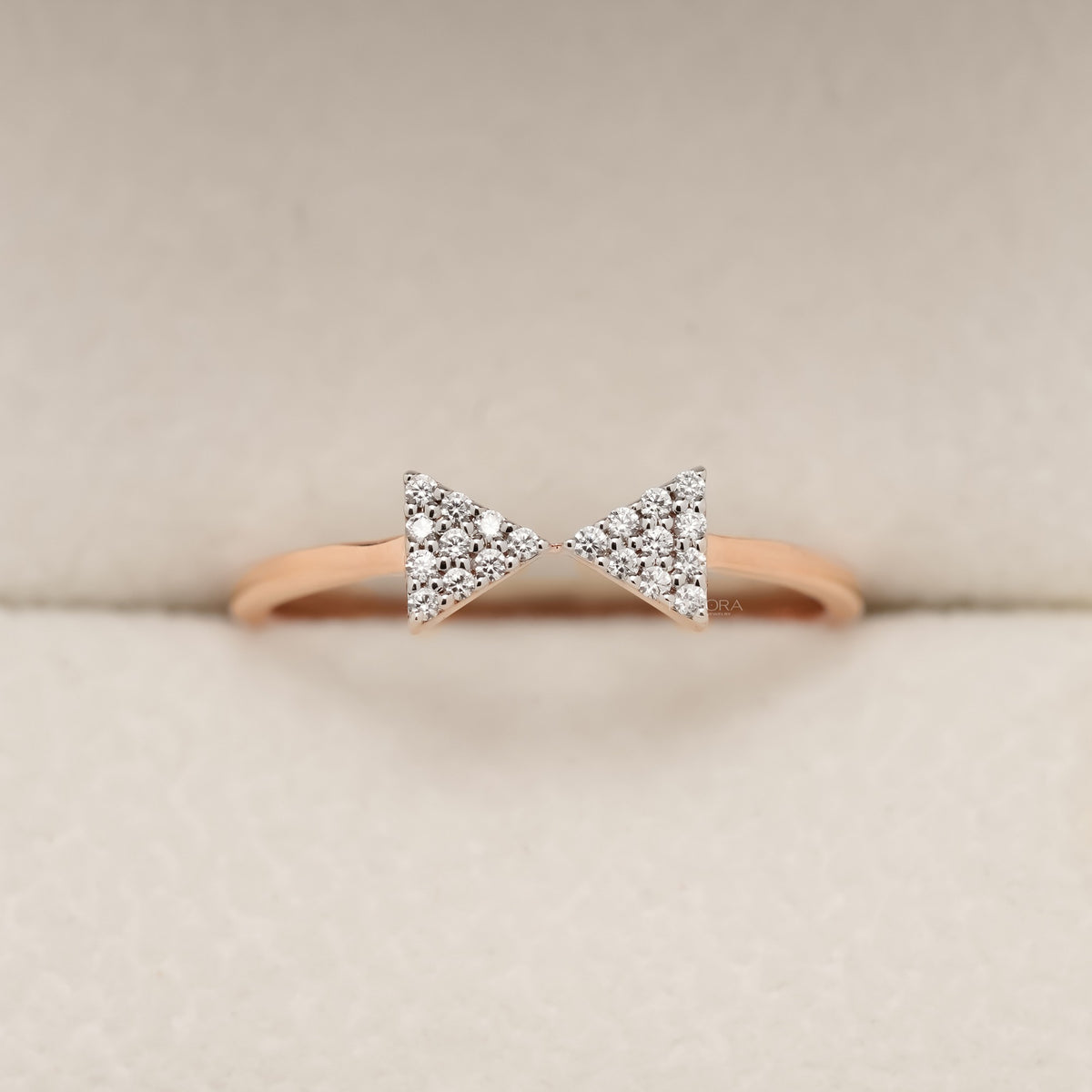 Round pave lab grown diamond cluster ring in rose gold with two triangle shaped bow clusters, front view in a ring box