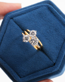 Top view of a round three stone lab grown diamond cluster ring in yellow gold in a blue velvet jewelry box