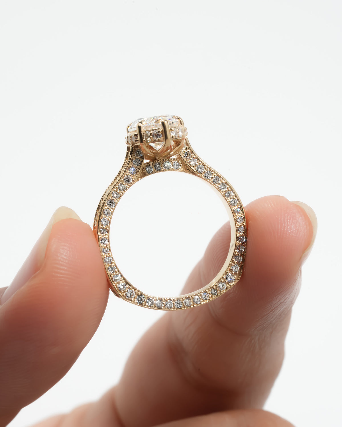 Vintage marquise lab grown diamond ring held upright showing the milgrain gallery