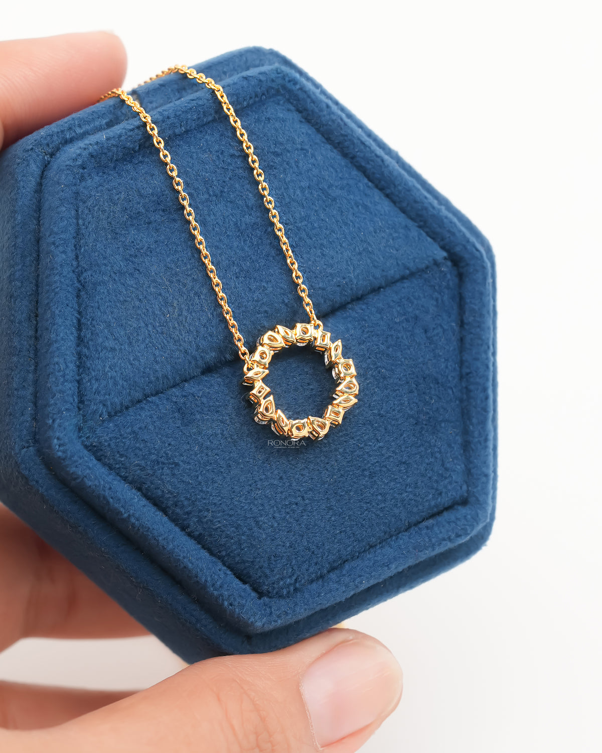 Back view of a wreath lab grown diamond necklace in yellow gold, open circle pendant in a blue velvet jewelry box