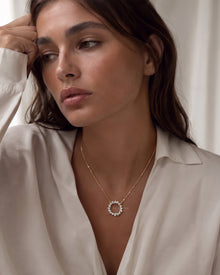Model wearing a wreath lab grown diamond necklace, an open circle pendant on a fine yellow gold chain