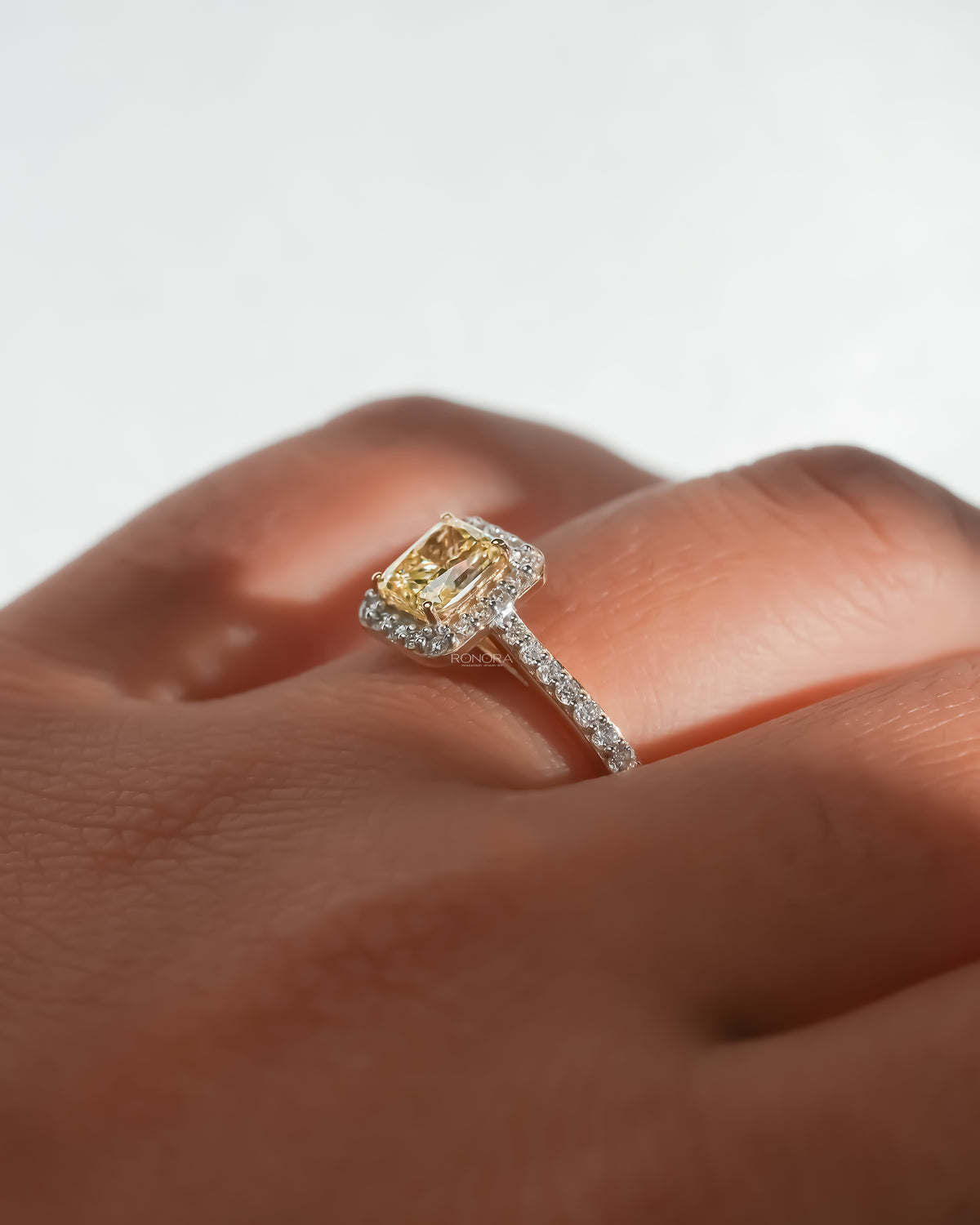 Close-up of the fancy yellow lab grown diamond halo ring on the finger