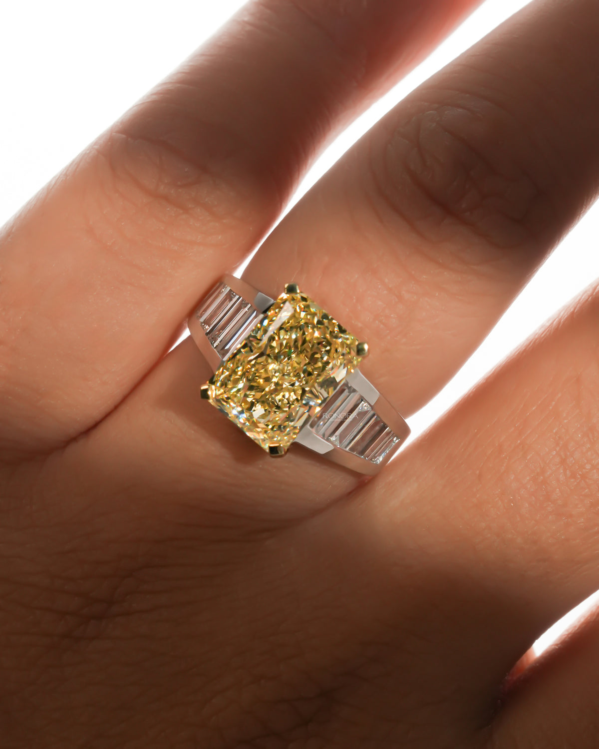 Close-up of the fancy yellow radiant lab grown diamond ring worn on the hand