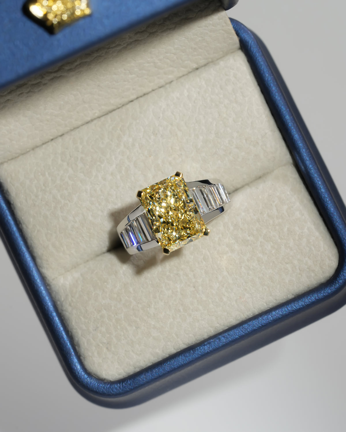 Fancy yellow radiant lab grown diamond ring in an open Ronora ring box