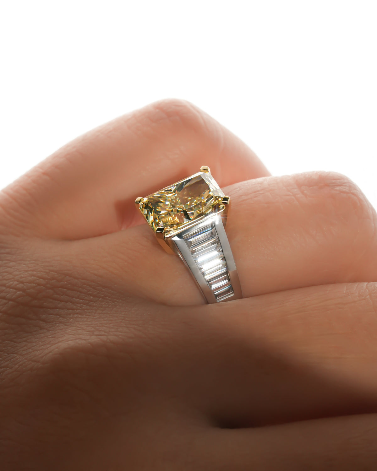 Fancy yellow radiant lab grown diamond ring on the finger showing the two tone setting